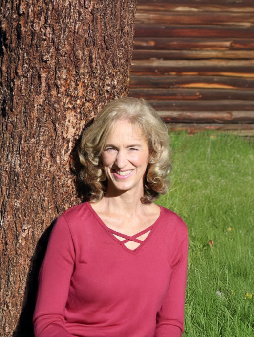 Smiling woman standing in front of a tree